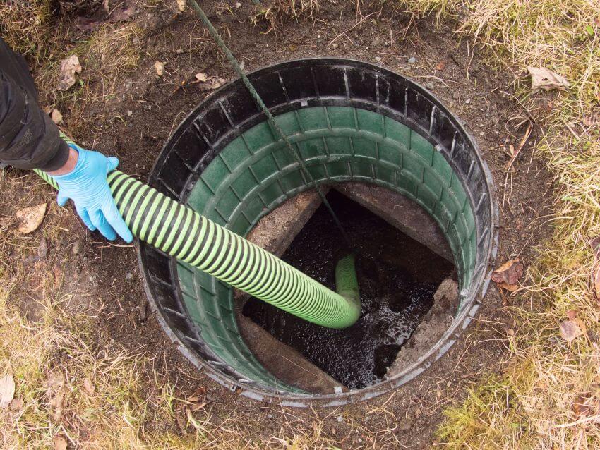 View down into septic tank with hose in it