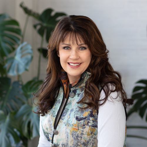 Brown-haired woman wearing a flowered vest