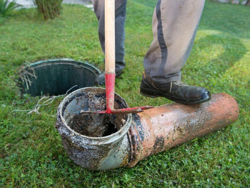 Man's foot on top of septic pipe laying on the ground
